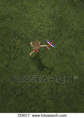 A girl playing with a toy airplane View Large Photo Image Stock Photo - A girl playing with a toy airplane. Fotosearch