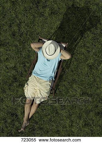 Stock Photography - A man sitting on a sun lounger. Fotosearch