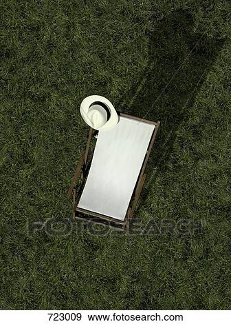 A sun lounger and a sun hat on a grass lawn View Large Photo Image Stock Photo - A sun lounger and a sun hat on a grass lawn. Fotosearch