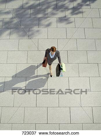 Stock Photo - A woman carrying shopping bags. Fotosearch