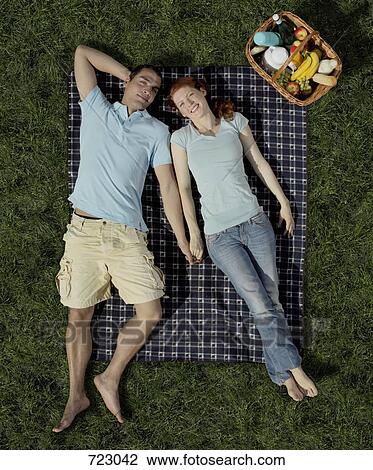 A young couple lying on a blanket with a hamper View Large Photo Image Stock Image - A young couple lying on a blanket with a hamper. Fotosearch