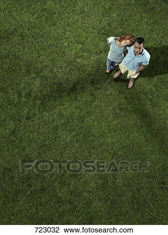 A young couple standing on the grass View Large Photo Image Stock Image - A young couple standing on the grass. Fotosearch