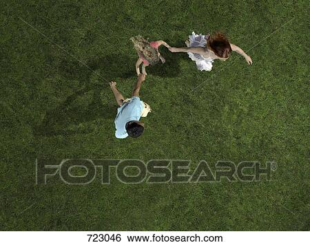 A young family holding hands and running on grass View Large Photo Image Stock Photograph - A young family holding hands and running on grass. Fotosearch