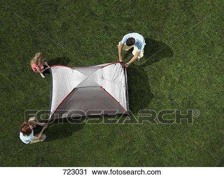 Stock Image - A young family putting up a tent. Fotosearch