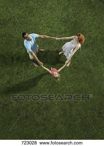 A young family standing in a circle holding hands View Large Photo Image Stock Photo - A young family standing in a circle holding hands. Fotosearch