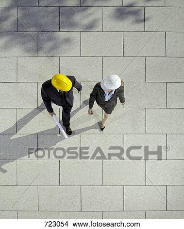 Two business people wearing hard hats View Large Photo Image Picture - Two business people wearing hard hats. Fotosearch