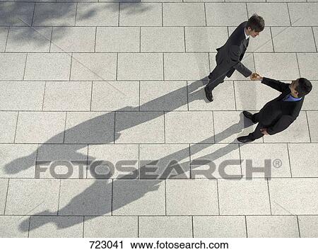 Stock Image - Two businessmen shaking hands. Fotosearch