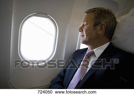 A businessman sleeping on a plane View Large Photo Image Stock Image - A businessman sleeping on a plane. Fotosearch