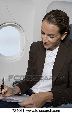 A businesswoman working on a plane View Large Photo Image Stock Image - A businesswoman working on a plane. Fotosearch