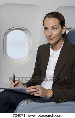 A businesswoman working on a plane View Large Photo Image Stock Image - A businesswoman working on a plane. Fotosearch