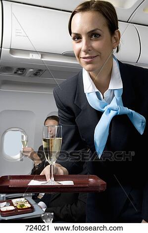A flight attendant serving champagne View Large Photo Image Stock Image - A flight attendant serving champagne. Fotosearch
