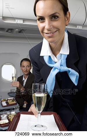 A flight attendant serving champagne View Large Photo Image Stock Photo - A flight attendant serving champagne. Fotosearch