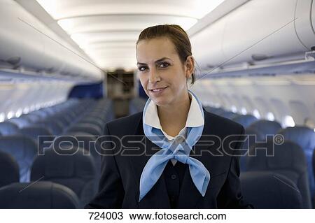 A flight attendant standing in the cabin of a plane View Large Photo Image Stock Image - A flight attendant standing in the cabin of a plane. Fotosearch