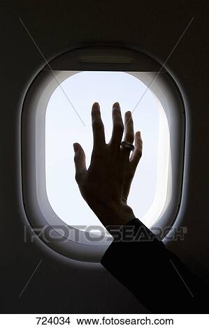 A hand on a commercial airplane window, silhouette View Large Photo Image Picture - A hand on a commercial airplane window, silhouette. Fotosearch