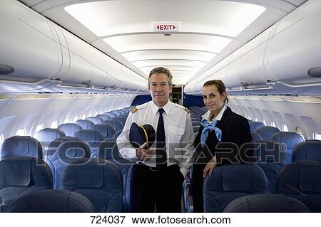 A pilot and a flight attendant standing in the cabin of a plane View Large Photo Image Stock Photo - A pilot and a flight attendant standing in the cabin of a plane. Fotosearch