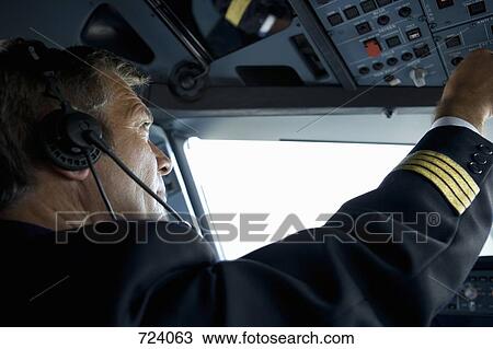 A pilot in the cockpit of a commercial plane View Large Photo Image Stock Image - A pilot in the cockpit of a commercial plane. Fotosearch