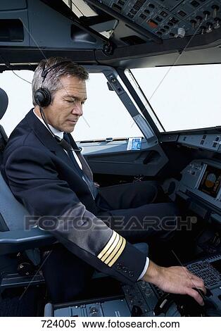 A pilot in the cockpit of a commercial plane View Large Photo Image Stock Photography - A pilot in the cockpit of a commercial plane. Fotosearch