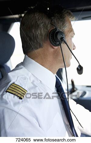 A pilot in the cockpit of a commercial plane View Large Photo Image Stock Photography - A pilot in the cockpit of a commercial plane. Fotosearch