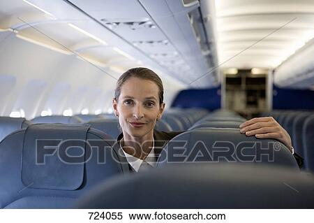 A woman looking over the top of airplane seats View Large Photo Image Stock Photography - A woman looking over the top of airplane seats. Fotosearch