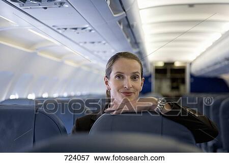 A woman resting her chin on the top of an airplane seat View Large Photo Image Stock Photo - A woman resting her chin on the top of an airplane seat. Fotosearch