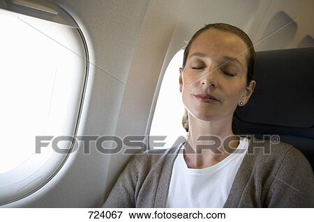 Stock Photo - A woman sleeping on a plane. Fotosearch