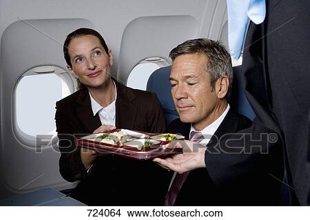 Business people on a plane being served airline food View Large Photo Image Picture - Business people on a plane being served airline food. Fotosearch
