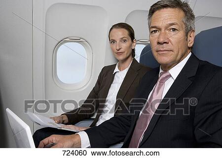 Two business people working on a plane View Large Photo Image Stock Image - Two business people working on a plane. Fotosearch