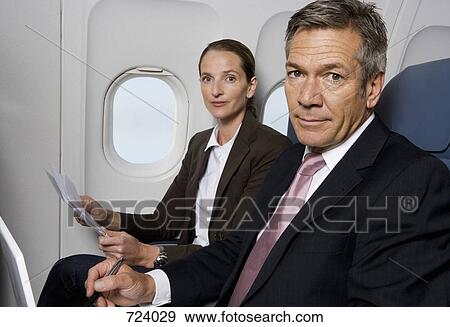 Two business people working on a plane View Large Photo Image Stock Photo - Two business people working on a plane. Fotosearch