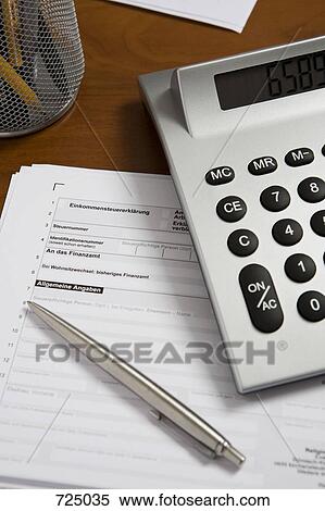 Stock Photography - A calculator and pen on top of a tax return form. Fotosearch