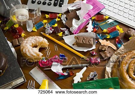 Picture - An office desk cluttered with candy and sweets. Fotosearch
