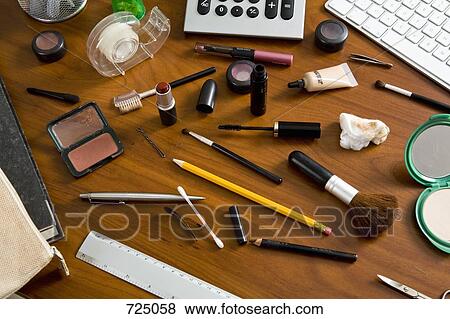An office desk cluttered with cosmetics and office supplies View Large Photo Image Stock Photo - An office desk cluttered with cosmetics and office supplies. Fotosearch
