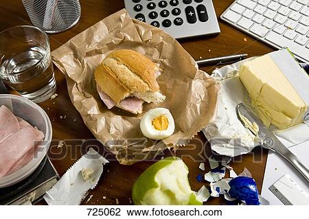 Stock Image - An office desk cluttered with food. Fotosearch