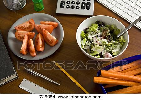 An office desk with office supplies and healthy food View Large Photo Image Picture - An office desk with office supplies and healthy food. Fotosearch
