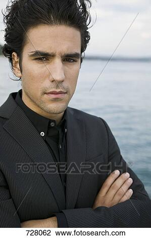 A man with his arms crossed by the sea View Large Photo Image Stock Image - A man with his arms crossed by the sea. Fotosearch