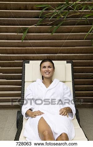 A woman lying in a lounge chair View Large Photo Image Stock Image - A woman lying in a lounge chair. Fotosearch