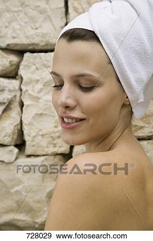 Stock Photo - A woman wearing a bathrobe and her hair in a towel looking flirtatious. Fotosearch
