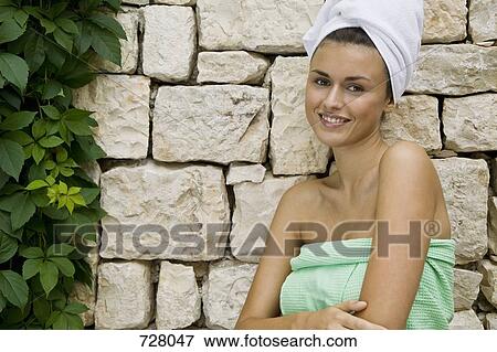 A woman wrapped in a towel looking flirtatious View Large Photo Image Stock Photo - A woman wrapped in a towel looking flirtatious. Fotosearch