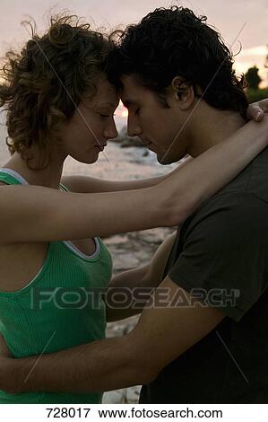 A young couple embracing View Large Photo Image Stock Photo - A young couple embracing. Fotosearch