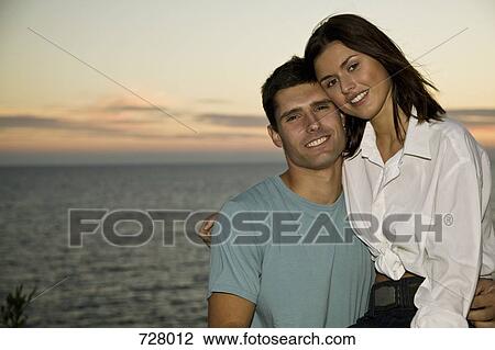 A young couple relaxing by the sea View Large Photo Image Stock Image - A young couple relaxing by the sea. Fotosearch