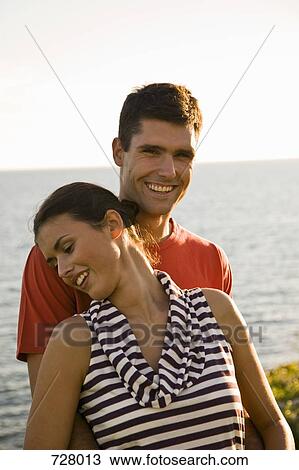 Stock Image - A young couple relaxing by the sea. Fotosearch