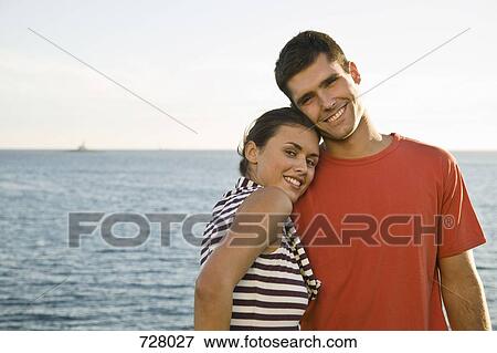 A young couple relaxing by the sea View Large Photo Image Stock Photo - A young couple relaxing by the sea. Fotosearch