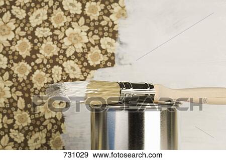Stock Photo - A half painted wall with a paint can and a paintbrush. Fotosearch