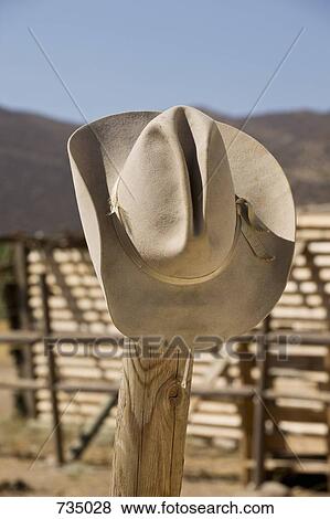 Stock Photo - A cowboy hat hanging on a fence. Fotosearch