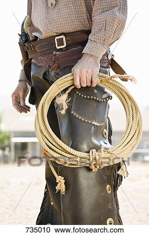 A cowboy holding a rope View Large Photo Image Stock Image - A cowboy holding a rope. Fotosearch