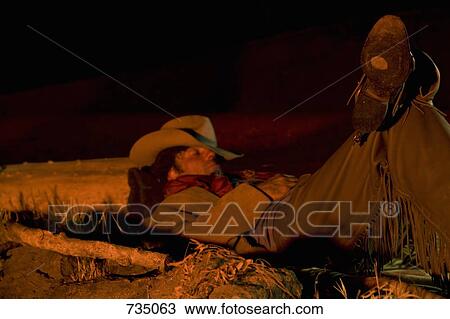 A cowboy illuminated by a campfire while sleeping View Large Photo Image Stock Image - A cowboy illuminated by a campfire while sleeping. Fotosearch
