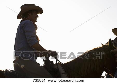 A cowboy riding a horse View Large Photo Image Stock Image - A cowboy riding a horse. Fotosearch