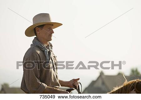 A cowboy riding a horse View Large Photo Image Stock Photo - A cowboy riding a horse. Fotosearch