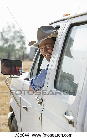 A man looking out of his truck window and smiling View Large Photo Image Picture - A man looking out of his truck window and smiling. Fotosearch