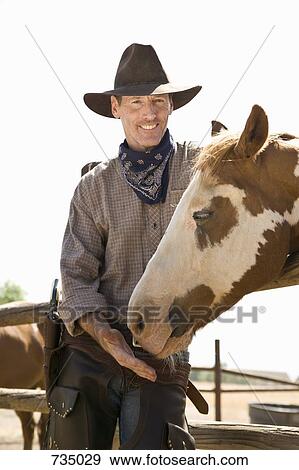 A rancher standing with his horse View Large Photo Image Stock Photo - A rancher standing with his horse. Fotosearch
