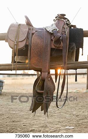 A saddle hanging on a fence View Large Photo Image Stock Image - A saddle hanging on a fence. Fotosearch